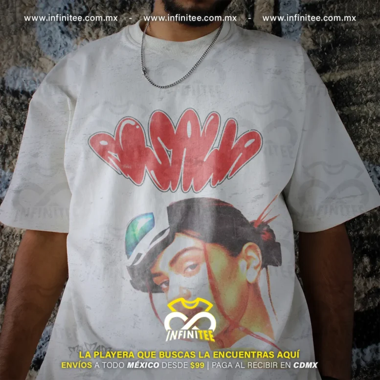 Fotografía de playera oversize blanca unisex con estampado de letras tipo graffiti rojo con el nombre Rosalía y retrato urbano con visera de la artista